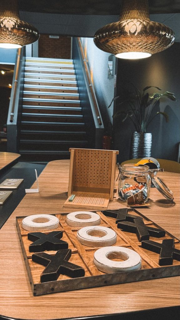 Warm and inviting indoor space with tic tac toe game on a table under pendant lights.